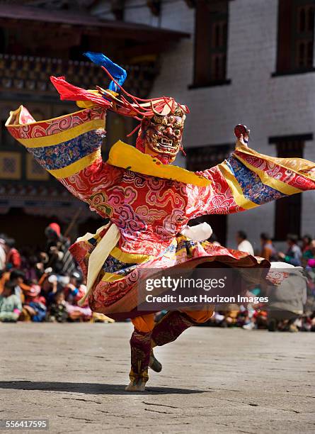 masked performer dancing at festival, punakha, bhutan - bhoutan photos et images de collection