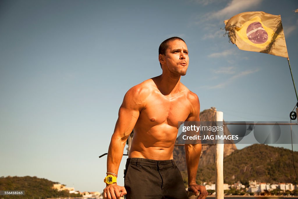 Mid adult man training on parallel bars, Rio De Janeiro, Brazil