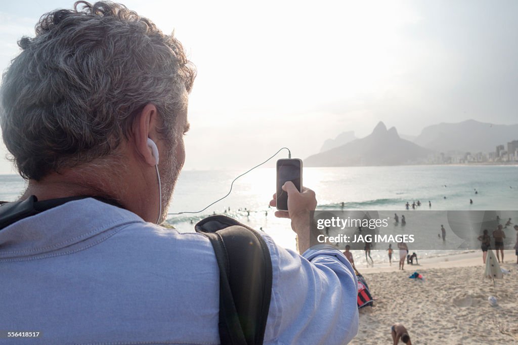 Man taking photo of view, Ipanema Beach, Rio de Janeiro, Brazil