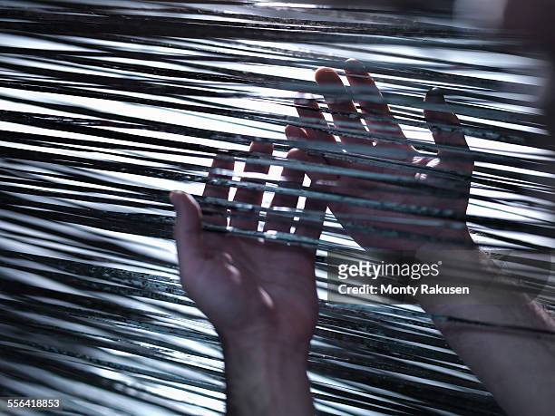 close up of hands holding carbon fibre on loom in carbon fibre factory - carbon fibre stockfoto's en -beelden