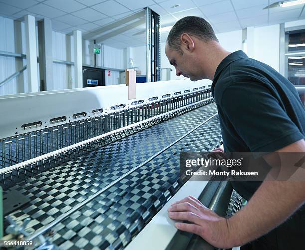 worker operating carbon fibre loom in carbon fibre factory - webstuhl stock-fotos und bilder