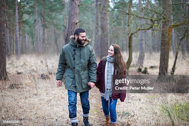 young couple strolling together in forest - parka stock pictures, royalty-free photos & images