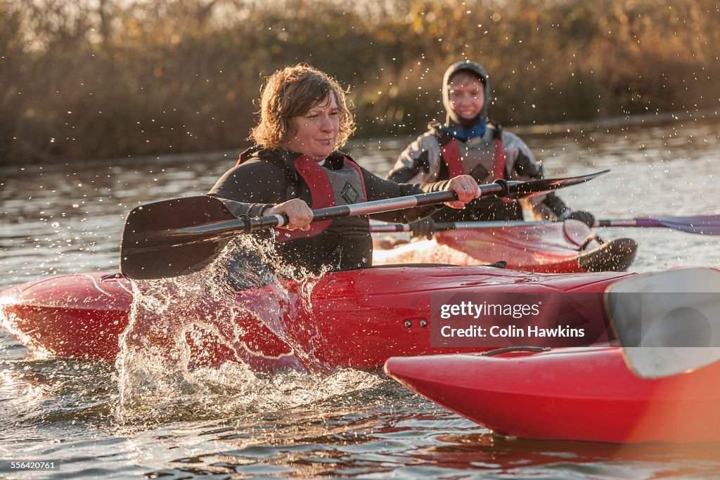 Mid adult women kayaking on lake
