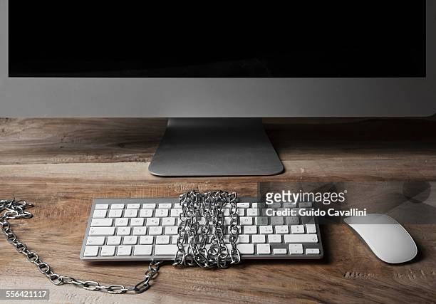 computer monitor and keyboard, chains wrapped around keyboard - censorship stockfoto's en -beelden