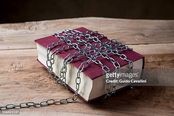 book with chains wrapped around it - limited stock-fotos und bilder