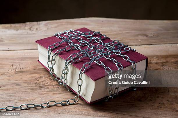 book with chains wrapped around it - denial stock pictures, royalty-free photos & images