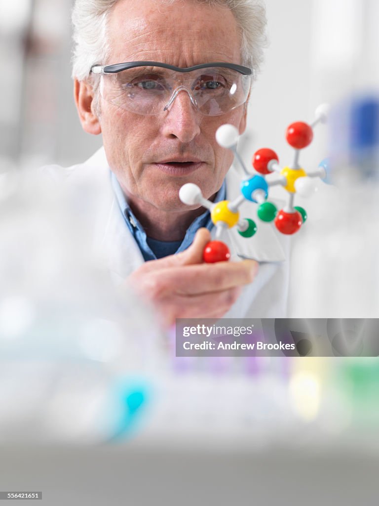 Scientist viewing molecular model of a chemical formula in a laboratory