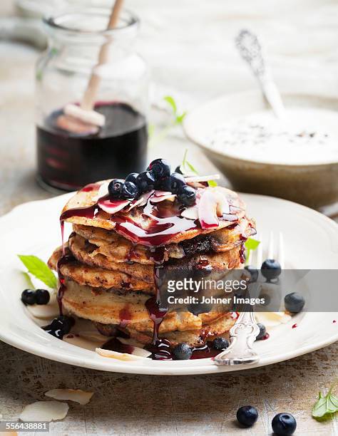 pancakes with sauce and blueberries - blueberry pancakes stock pictures, royalty-free photos & images