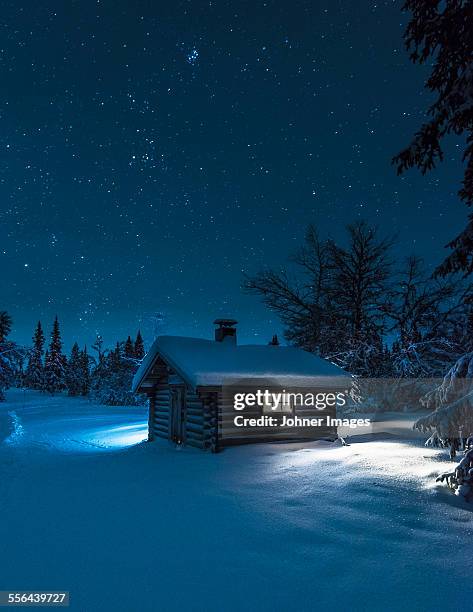 illuminated log house at night - cabin stock pictures, royalty-free photos & images