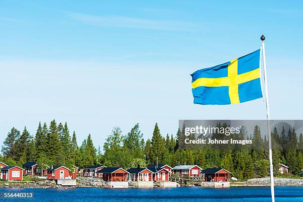 coastal houses, swedish flag on foreground - swedish flag ストックフォトと画像