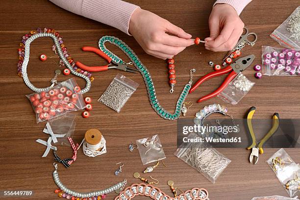 young woman working on self-made jewelry - bracelet fotografías e imágenes de stock