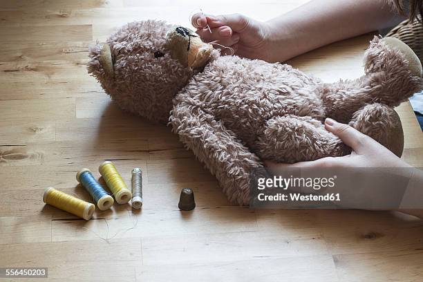 woman's hands repairing old teddy-bear - old stuffed toy stock pictures, royalty-free photos & images