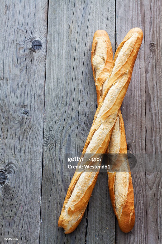 Two French baguettes on grey wood