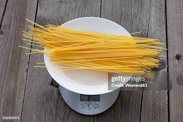 row spaghetti on plate and scale on wood - massa-não-cozinhada imagens e fotografias de stock