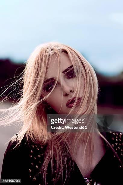 portrait of blond woman with blowing hair - frau haarsträhne blond beauty stock-fotos und bilder