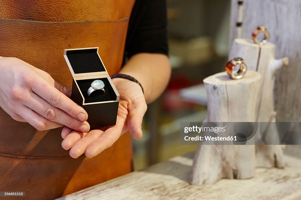Goldsmith in her shop presenting jewelry box