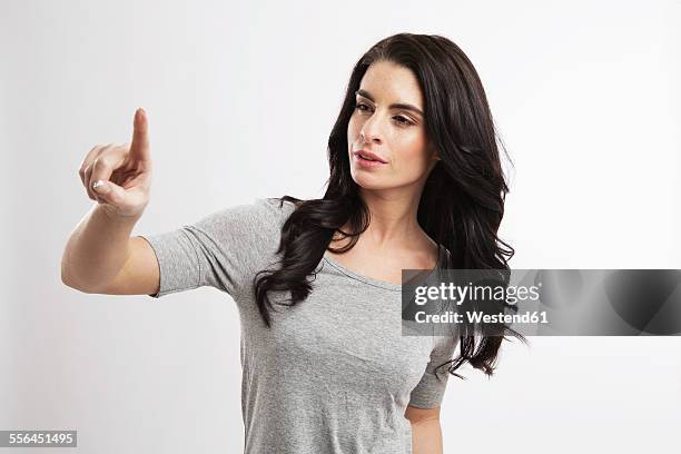 portrait of young woman pointing in the air - 人差し指 女性 ストックフォトと画像