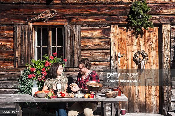 austria, altenmarkt-zauchensee, couple having a break at alpine cabin - alpine lodge stock-fotos und bilder