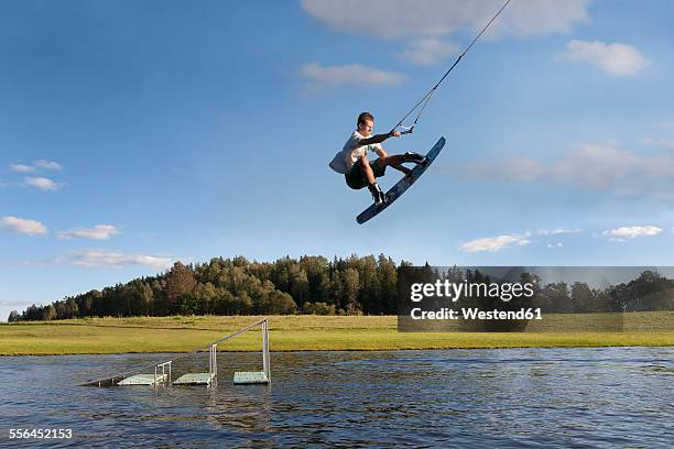 estonia, otepaa wakepark, young man wakeboarding - skateboard rampe stock-fotos und bilder