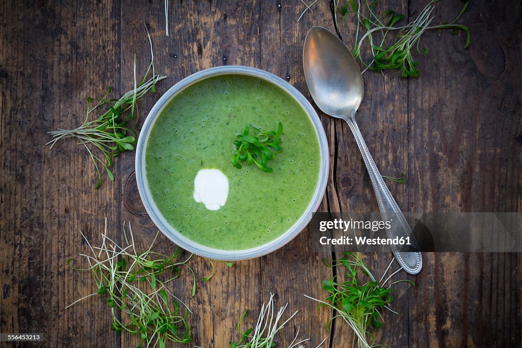 Cress soup in bowl on dark wood
