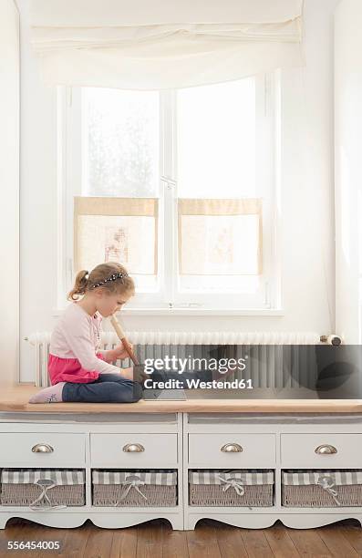 little girl playing recorder at home - blockflöte stock-fotos und bilder