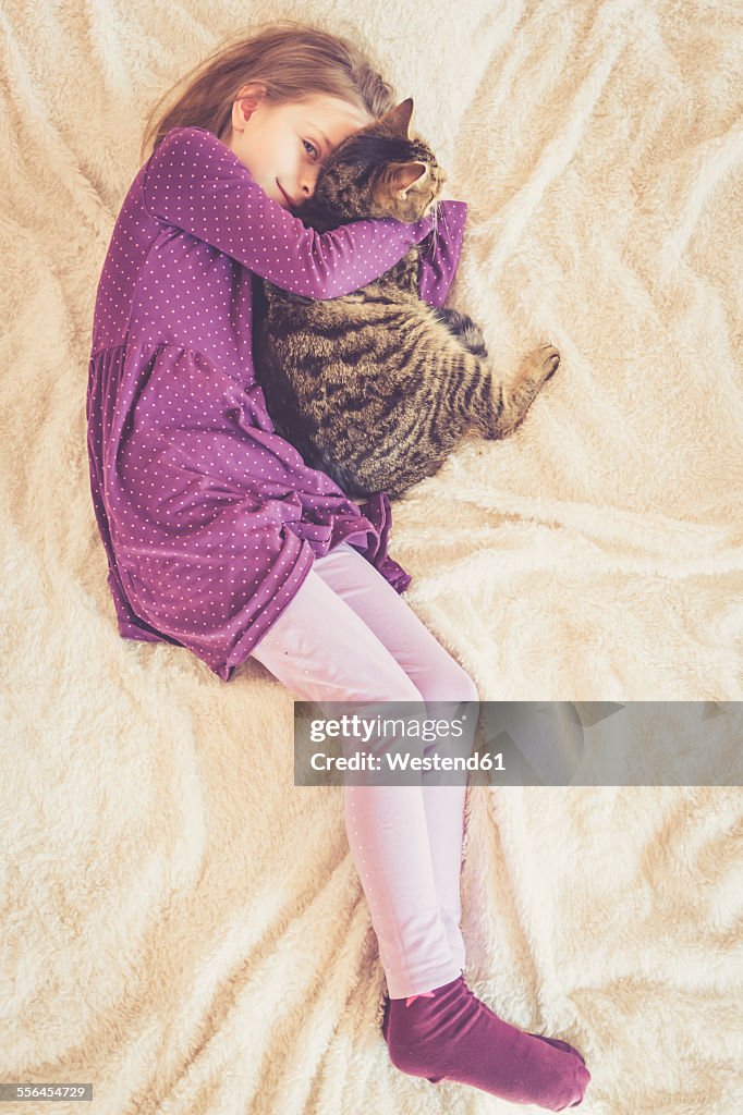 Girl cuddling with cat