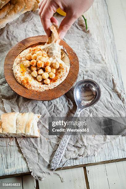 hand dipping turkish flatbread into hummus - hummus food stock pictures, royalty-free photos & images