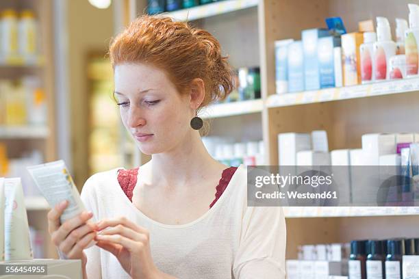 female customer informing in an organic shop - magasin cosmétique photos et images de collection