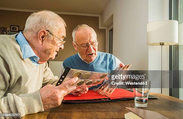 two senior friends with coin album - coin collection stock pictures, royalty-free photos & images