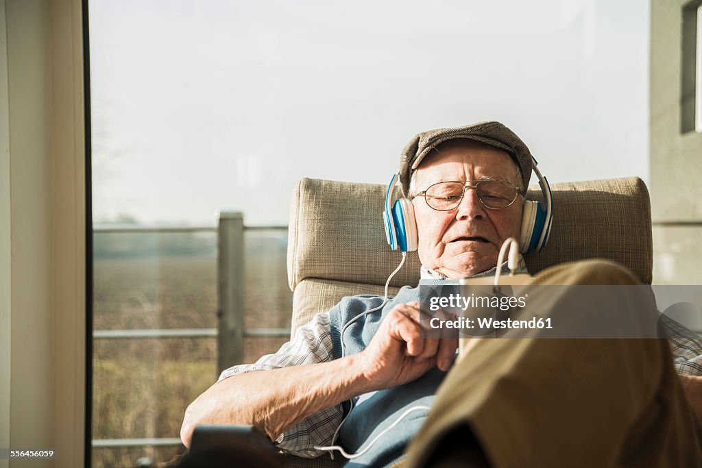 Senior man at home relaxing with headphones