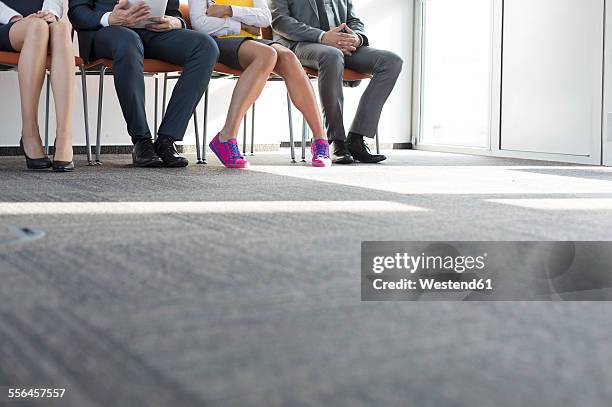 people sitting in a row, waiting for job interview - arbeitslosigkeit stock-fotos und bilder