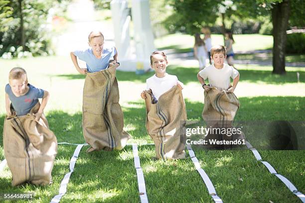 boys competing in a sack race - sack race stock pictures, royalty-free photos & images