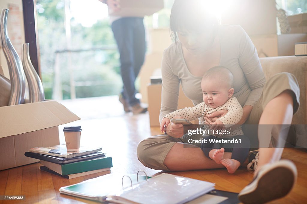 Family moving house, mother sitting with a baby