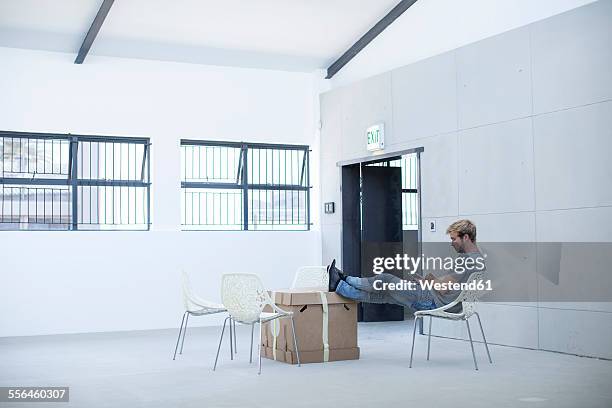 creative office man relaxing on a chair and boxes - makeshift office stock pictures, royalty-free photos & images