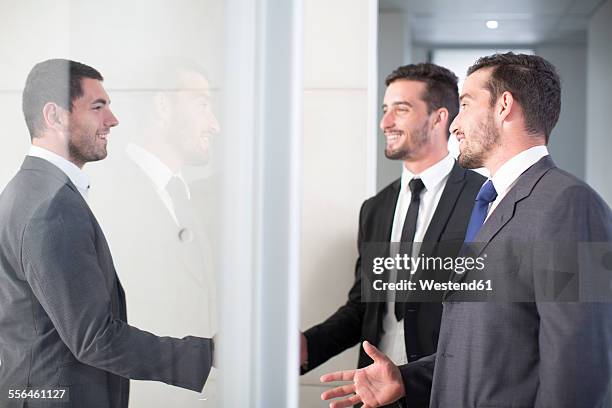 businessmen shaking hands in office - brother handshake stock pictures, royalty-free photos & images