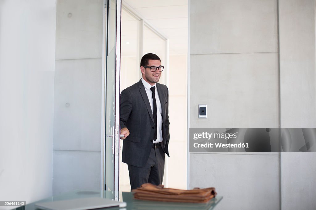 Businessman in suit opening boardroom door