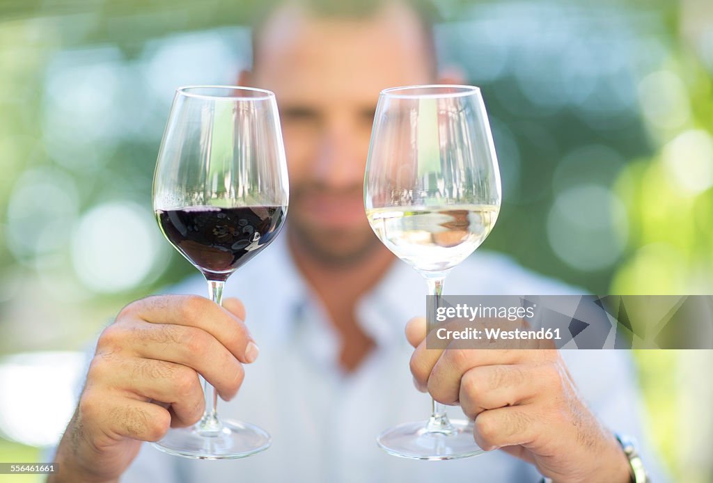 Man comparing white wine and red wine on a wine tasting session
