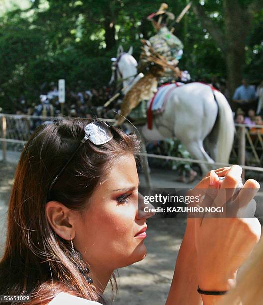 Miss France Cynthia Tevere, takes a picture of a rider during an annual shito festival 'Yabusame', Japanese traditional archery on horseback, at the...