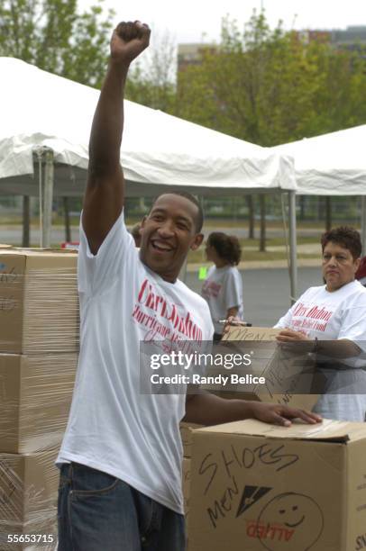 Chris Duhon of the Chicago Bulls cheers on the efforts of volunteers that assisted with the collection of food and clothing items donated as part of...