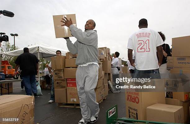 Former Chicago Bull Jay Williams pitches in by moving one of the many boxes of food and clothing items donated as part of the Chris Duhon Hurricane...