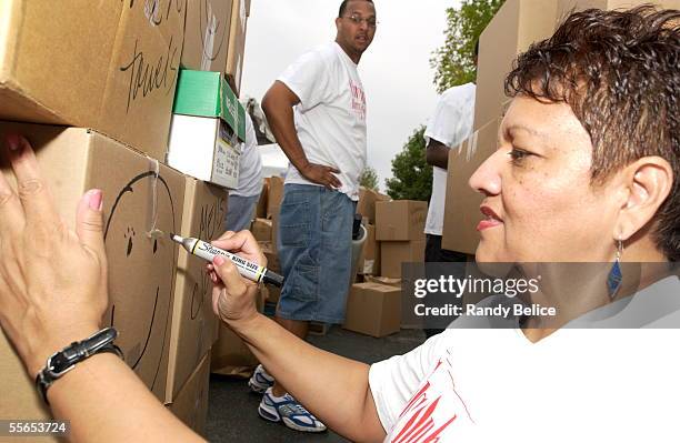 Sandra Killion of Chicago adds a happy face marking to a box of food and clothing items donated as part of the Chris Duhon Hurricane Fund relief...