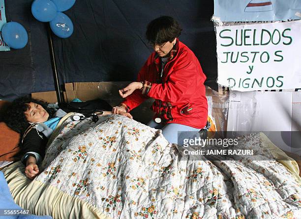 Una enfermera en huelga de hambre es controlada por un colega en una carpa en el atrio de una iglesia en Lima el 16 de setiembre de 2005 en Lima,...