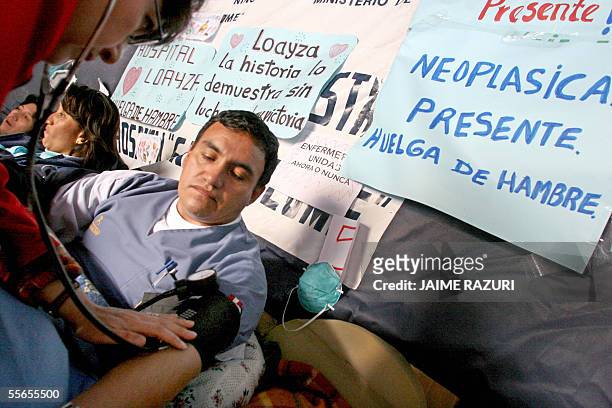 Un enfermero en huelga de hambre es controlado por un colega en una carpa en el atrio de una iglesia 16 de setiembre de 2005 en Lima. El grupo en...