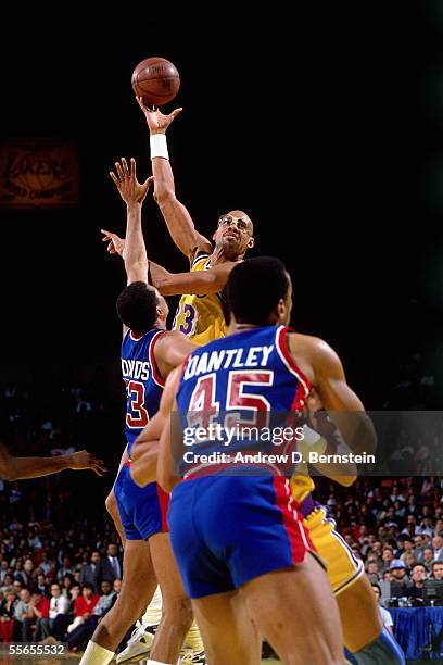 Kareem Abdul-Jabbar of the Los Angeles Lakers shoots a sky hook against James Edwards and Adrian Dantley of the Detroit Pistons February 14, 1989 at...