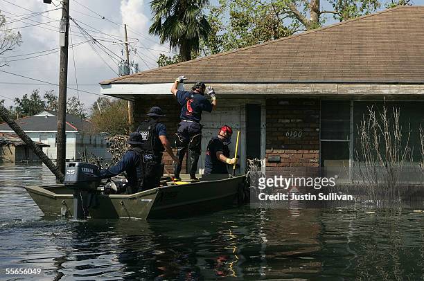 Rescue workers attempt to break down a door as they search homes still under water in the Lakefront District September 16, 2005 of New Orleans,...