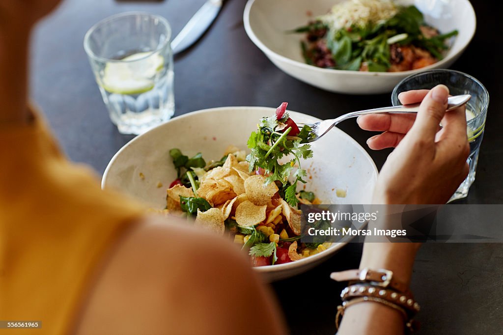 Woman having food at restaurant table