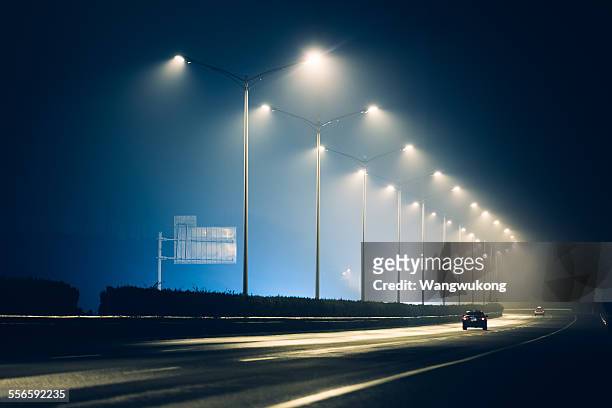 the highway lamps - light car night stock-fotos und bilder
