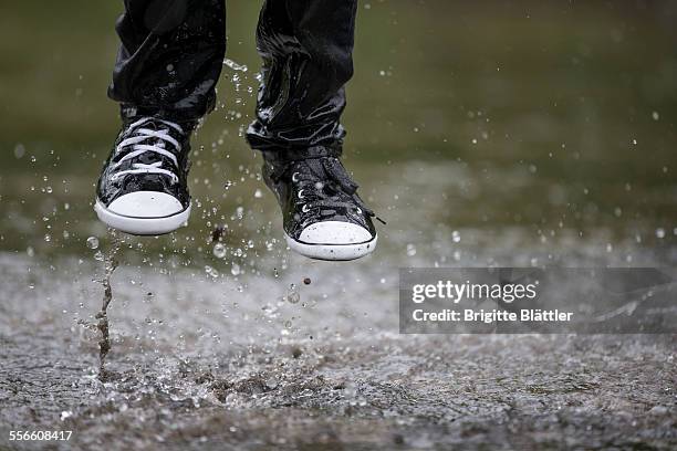 kid jumping in water - wet jeans stock-fotos und bilder