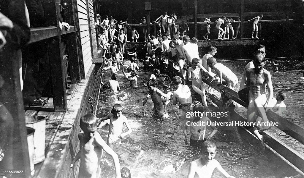 City children swimming (most without suits) in public pool at the Battery, New York City. 1908-1916.