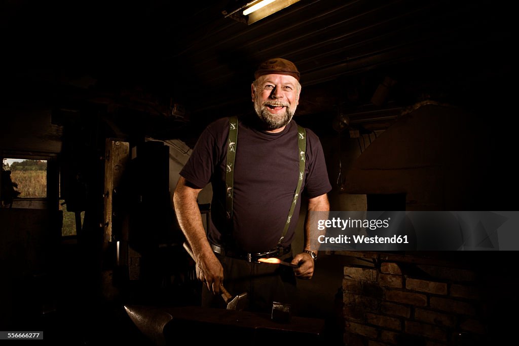 Portrait of happy blacksmith in his workshop